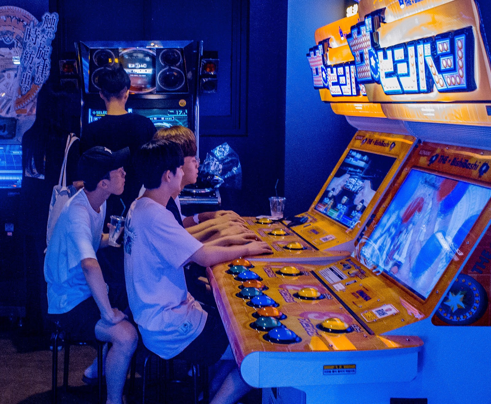 A group of young adults playing an arcade game.