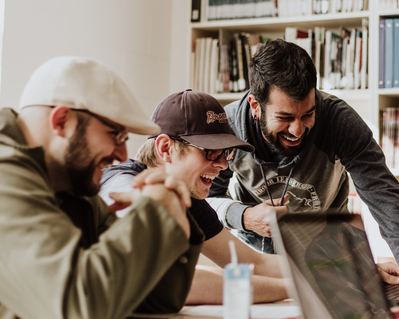 A group of people engaged around a computer.
